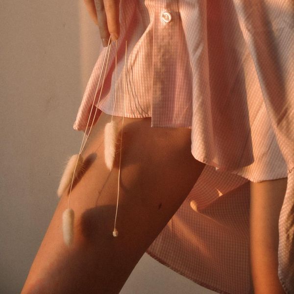 Woman meditating peacefully with a soft pink light aura.